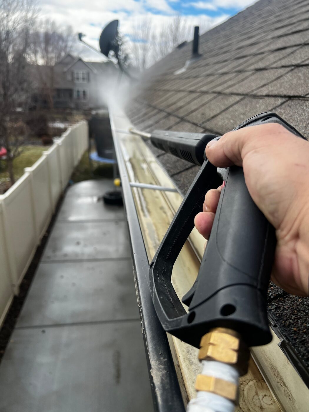 Close-up of gutter flushing and pressure washing equipment clearing a residential gutter in Sydney