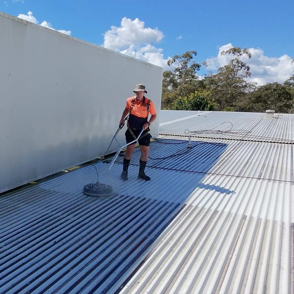 High-pressure roof surface cleaning on a Sydney commercial metal roof