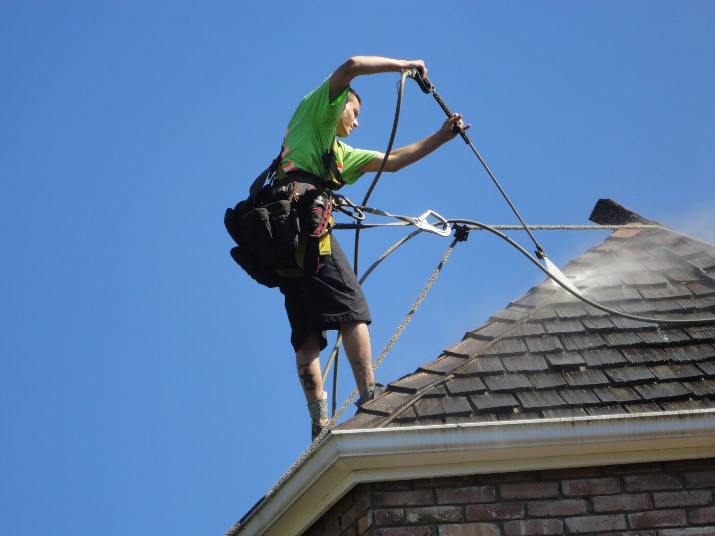 Roof pressure washing on a tiled Sydney roof using safety harness access